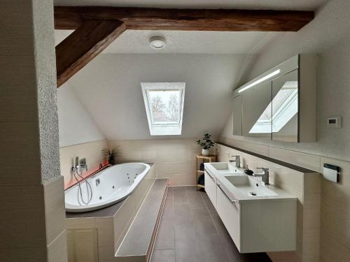 a bathroom with a tub and a sink and a mirror at Ferienwohnung Parkblick in Bad Elster