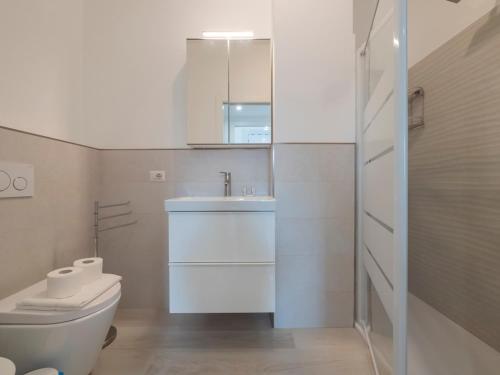 bagno bianco con lavandino e servizi igienici di [IHost Flat] - Giambellino 131-2 a Milano