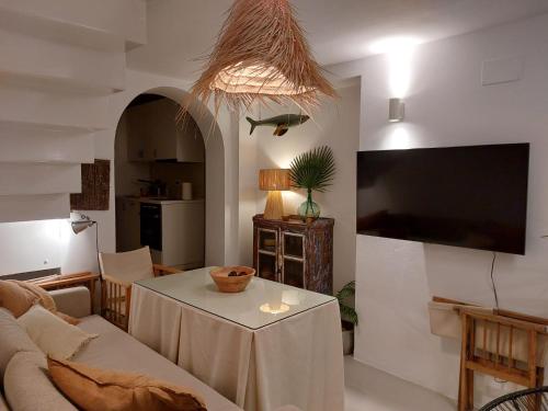 a living room with a table and a tv at La Niña de Vejer in Vejer de la Frontera