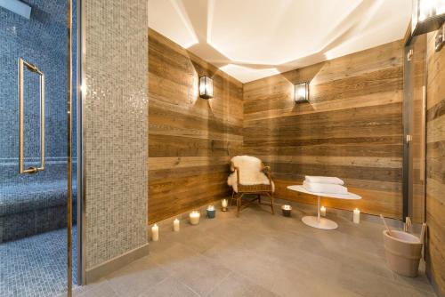 a room with a wooden wall with a chair and candles at Les Chalets Du Jardin Alpin in Val-d'Isère