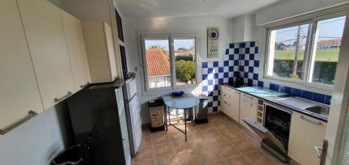 a kitchen with blue and white tiles on the wall at Maison bleu océan in Saint-Palais-sur-Mer