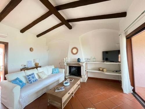 Una sala de estar con un sofá blanco y una mesa. en EdelBlu - Breathtaking seaview penthouse, en Castelsardo