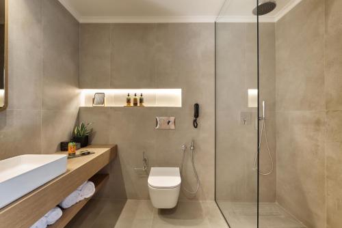 a bathroom with a shower and a toilet and a sink at Inea Sole Boutique Hotel in Kato Daratso