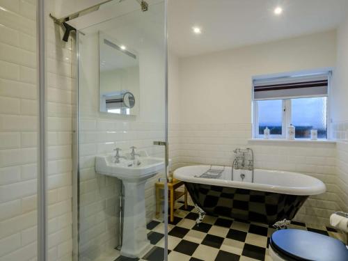 ein Bad mit einer Badewanne, einem Waschbecken und einer Dusche in der Unterkunft 3 Bed in Sedgeford 90011 in Sedgeford