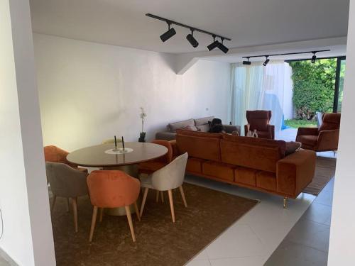 a living room with a couch and a table and chairs at Maison avec jardin à 2 minutes à pied de la plage in Temara