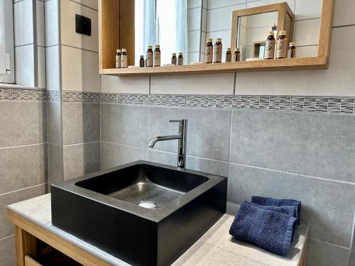 une salle de bain avec un lavabo noir et un miroir dans l'établissement Appartement de Charme avec Balcon - Villa les IRIS, à Dunkerque