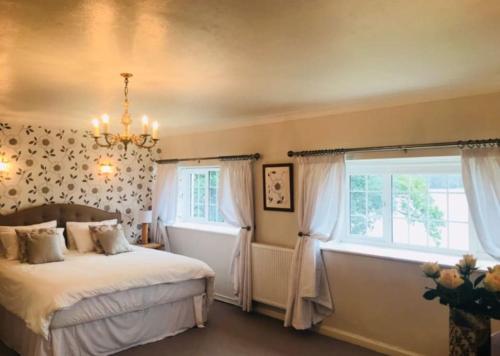 a bedroom with a bed and a large window at Beach Cottage, with stunning views in Cosheston