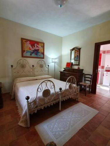 a bedroom with a bed and a table and a chair at Agrifoglio B&B con giardino in Aritzo