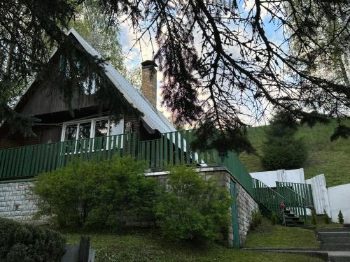 a house with a green fence in front of it at Chata Zbyšek in Prostřední Bečva