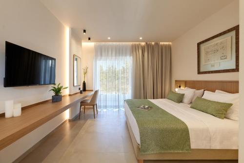 a hotel room with a bed and a flat screen tv at Inea Sole Boutique Hotel in Kato Daratso
