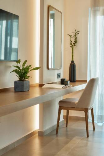 a bathroom with a desk with a chair and a mirror at Inea Sole Boutique Hotel in Kato Daratso