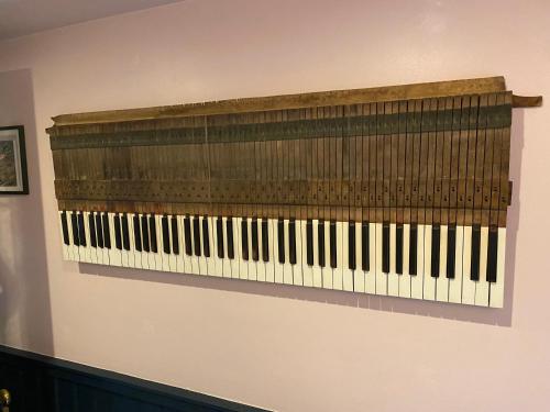 a wooden keyboard hanging on a wall at Stone Cottage in Norwich