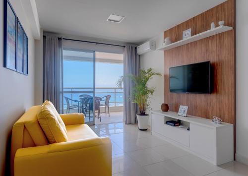 a living room with a yellow couch and a television at Casa da Geo Ondina - Frente de Praia in Salvador
