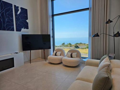 a living room with two couches and a flat screen tv at B202 OceanView 돌고래출몰 수영장 노래방 스크린골프 in Seogwipo