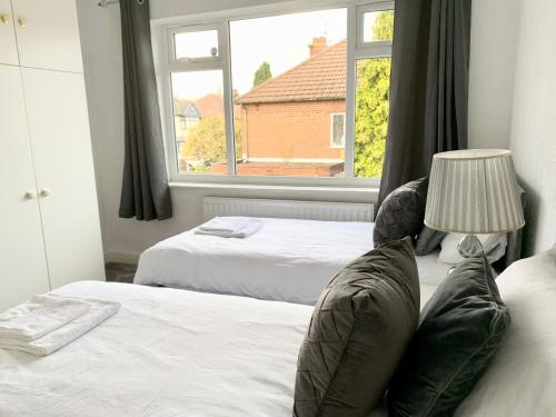a bedroom with two beds and a window at Immaculate 3-Bed Travel nest unavailable in Manchester