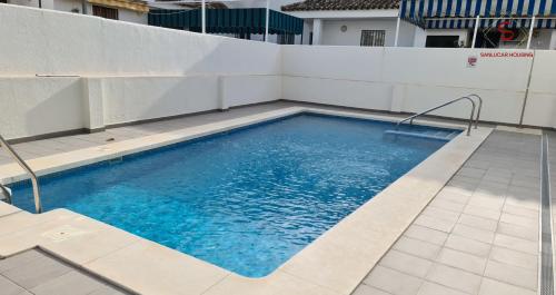 a swimming pool on top of a building at Arenas de Doñana amplio apartamento frente del mar in Sanlúcar de Barrameda