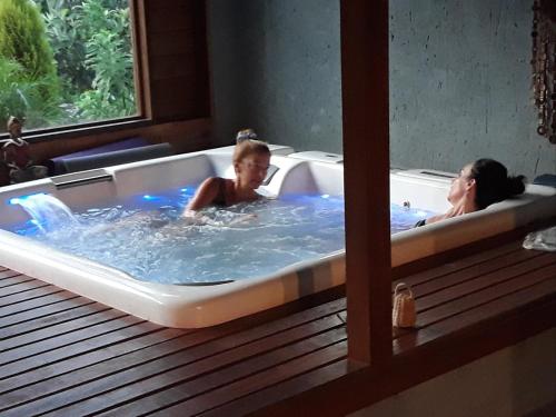 two people in a hot tub in a room at Pousada Alma da Gamboa in Gamboa