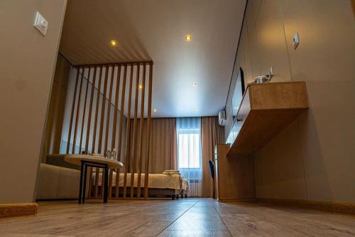 um quarto com uma escada, uma cama e uma mesa em Fly Apartment em Prigorodnyy