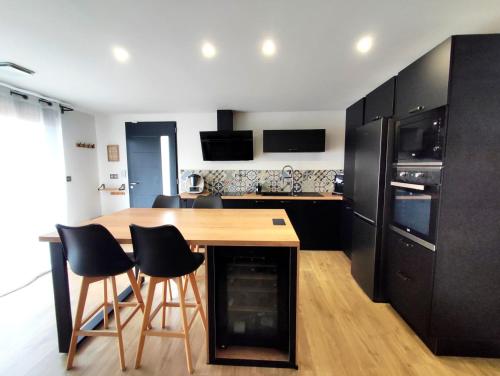 uma cozinha com uma mesa de madeira e electrodomésticos pretos em Villa du Pont du Gard em Castillon-du-Gard