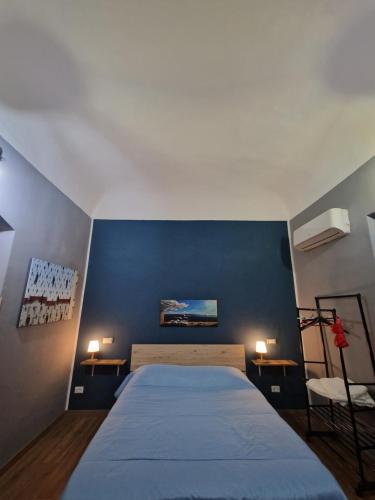 1 dormitorio con 1 cama con pared azul en Tuppulia e Cusciulia near Cathedral, en Palermo