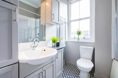 a white bathroom with a sink and a toilet at Large 1 Bedroom in Center of London in London