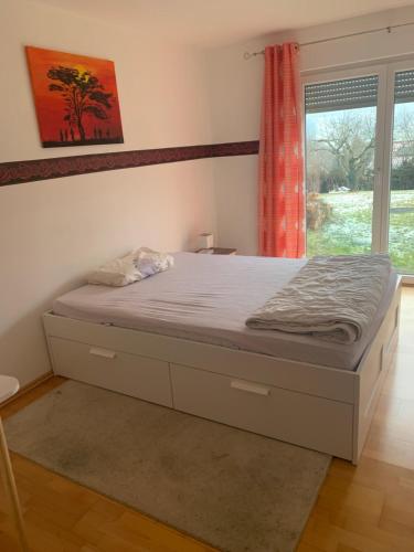 een bed in een slaapkamer met een raam bij Ferienappartment in Pliezhausen