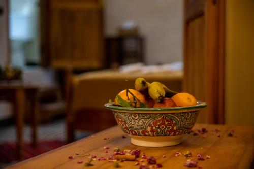 a bowl of fruit on top of a wooden table at Dar alhaja rahma in Fès