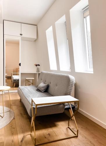 una sala de estar con un sofá y una mesa en Apartman Snow White Bjelasnica, en Bjelašnica