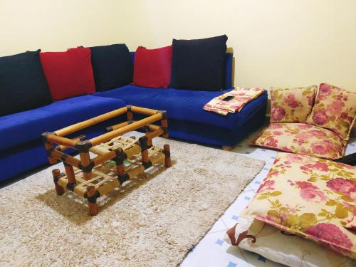 ein Wohnzimmer mit einem blauen Sofa und einem Teppich in der Unterkunft Gill's Crib in Maseno