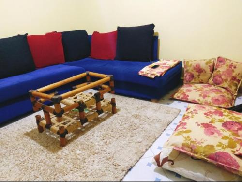 a living room with a blue couch and a rug at Gill's Crib in Maseno