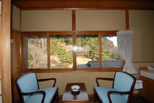 a room with two chairs and a table and a window at Sansuien in Yamaguchi