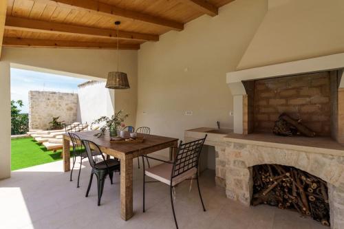 a dining room with a table and a fireplace at Villa Santina by Briskva in Višnjan