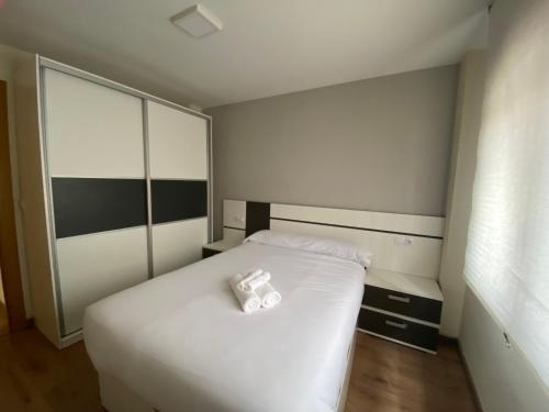 a bedroom with a white bed and a large window at APARTAMENTO NEVADA in Pinos Genil