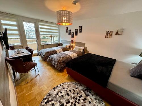 a bedroom with two beds and a chandelier at Sunset View Apartment with Logia in Ettlingen