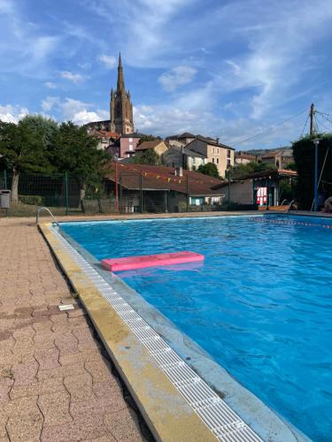 an empty swimming pool with a church in the background at CAMPING VERT LAVANDE in Belmont-sur-Rance