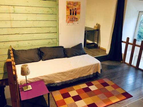 - une chambre avec un lit et une table avec un tapis dans l'établissement Maison spacieuse et calme à la campagne, à Saint-Denis-sur-Sarthon