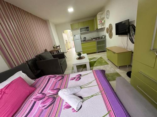1 dormitorio con cama rosa y cocina en Lilly Skopje en Skopie