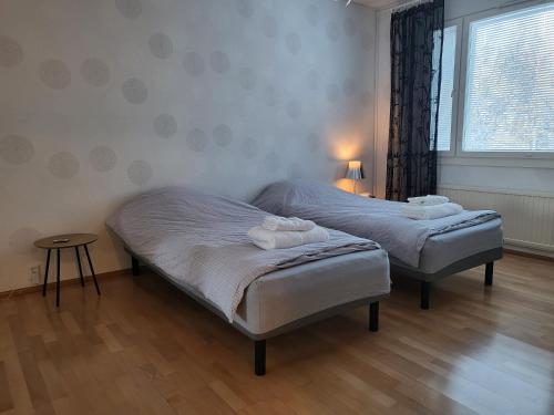1 dormitorio con 2 camas y ventana en Home Apartment Haukipudas, en Oulu