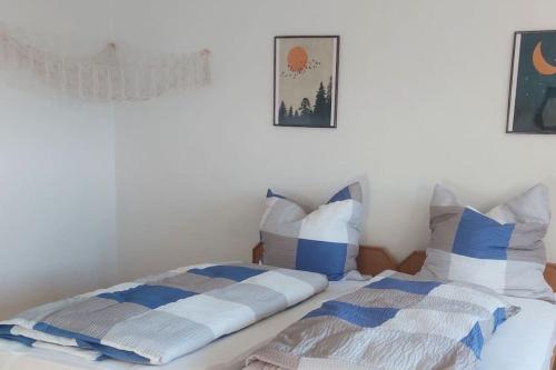 a bed with blue and white pillows on it at Apartment mit Bergblick in Fürstenstein