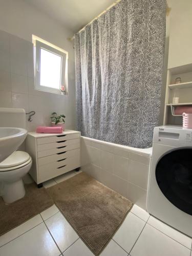 a bathroom with a tub and a toilet and a sink at Apartman Jadro in Solin