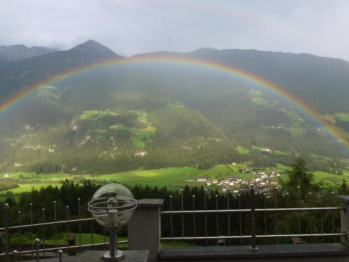 a rainbow over a valley with a town at Gasthof Bauhof in Villa Ottone