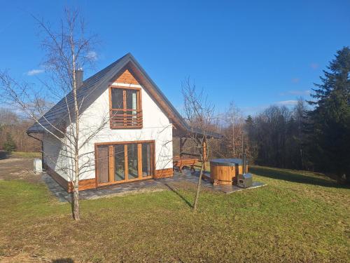 a small house on top of a field at Leśna Chata domek z balią in Sękowa