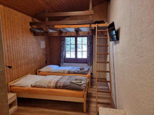 2 łóżka piętrowe w pokoju z drabiną w obiekcie Le Catogne w mieście Orsières