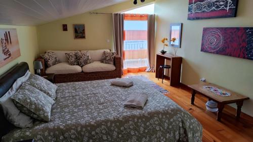 uma sala de estar com uma cama e um sofá em Vista Romantica Madeira em Arco da Calheta