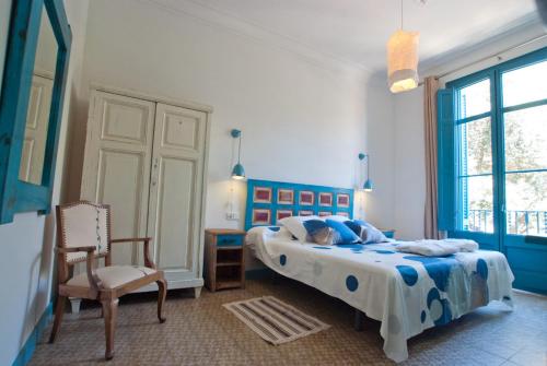 a bedroom with two beds and a chair at Hotel Hostal Chic in Sant Feliu de Guíxols
