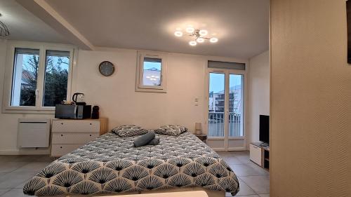 a bedroom with a bed and a tv and windows at Studio Cosy avec balcon et garage privé in Le Mans