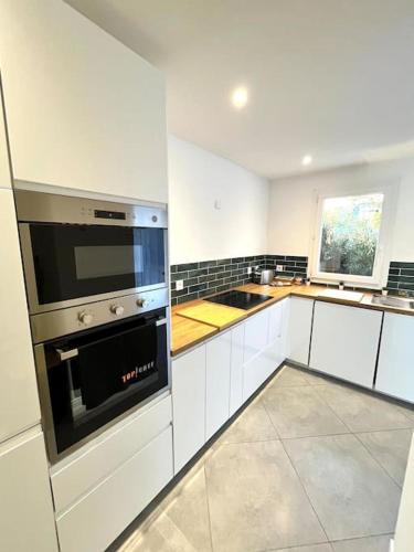 a kitchen with white cabinets and a stove top oven at Villa Victoria #8 persons #3 Bedrooms #Terrace # garage Beach - Calm and Clim in Roquebrune-Cap-Martin
