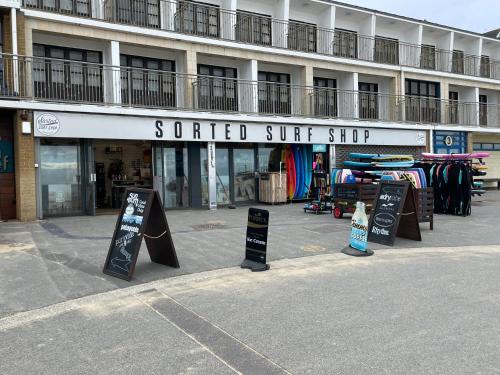 aented surf shop with signs in front of a building at Burlington Mansions in Bournemouth