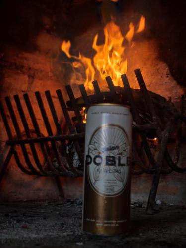 a can of beer sitting in front of a fire at Alojamiento Quincho Pascual in Las Compuertas