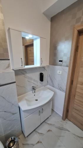 a bathroom with a sink and a tub and a mirror at Jafar Resort 7 in Timişoara